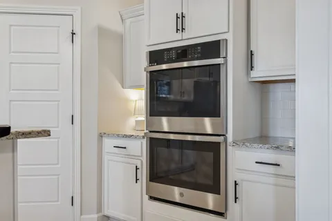 a kitchen with granite countertop a sink a counter space appliances and cabinets