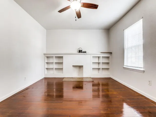 a view of a room with wooden floor and white walls