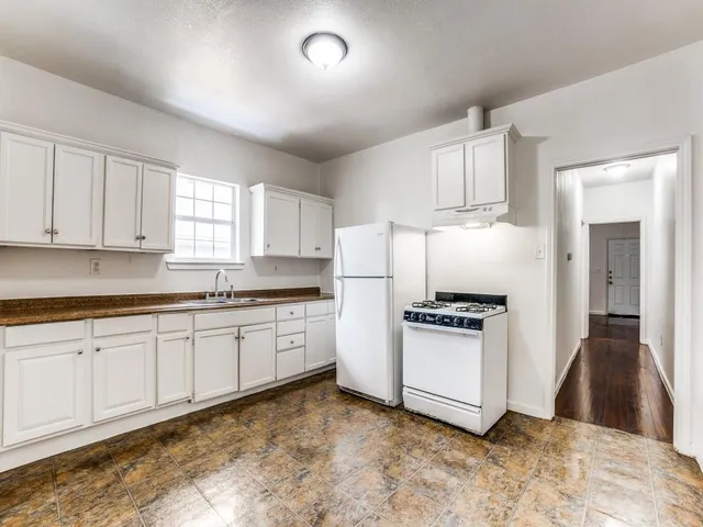 a kitchen with granite countertop white cabinets and white appliances