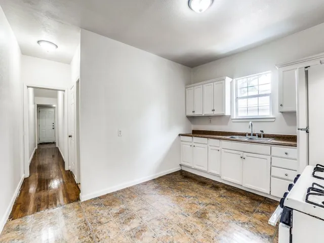a kitchen with granite countertop a sink cabinets and a window