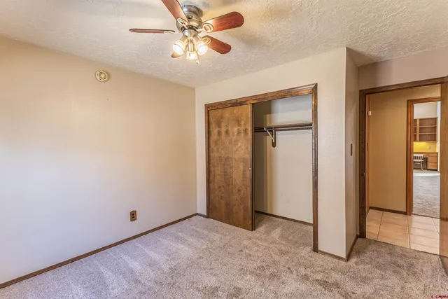 an empty room with window and ceiling fan