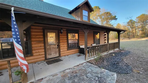 a view of house with a large window and wooden fence