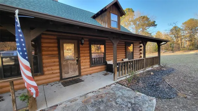 a view of house with a large window and wooden fence