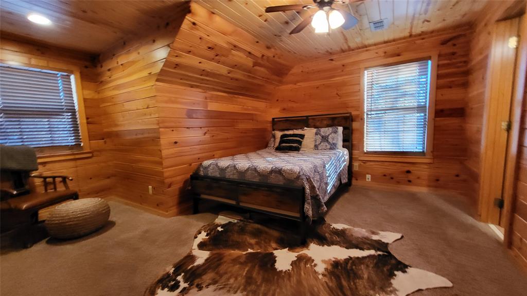 9 Private Road Leesburg, TX 75451 - Photo 26 of 26 a bedroom with a bed and a chandelier