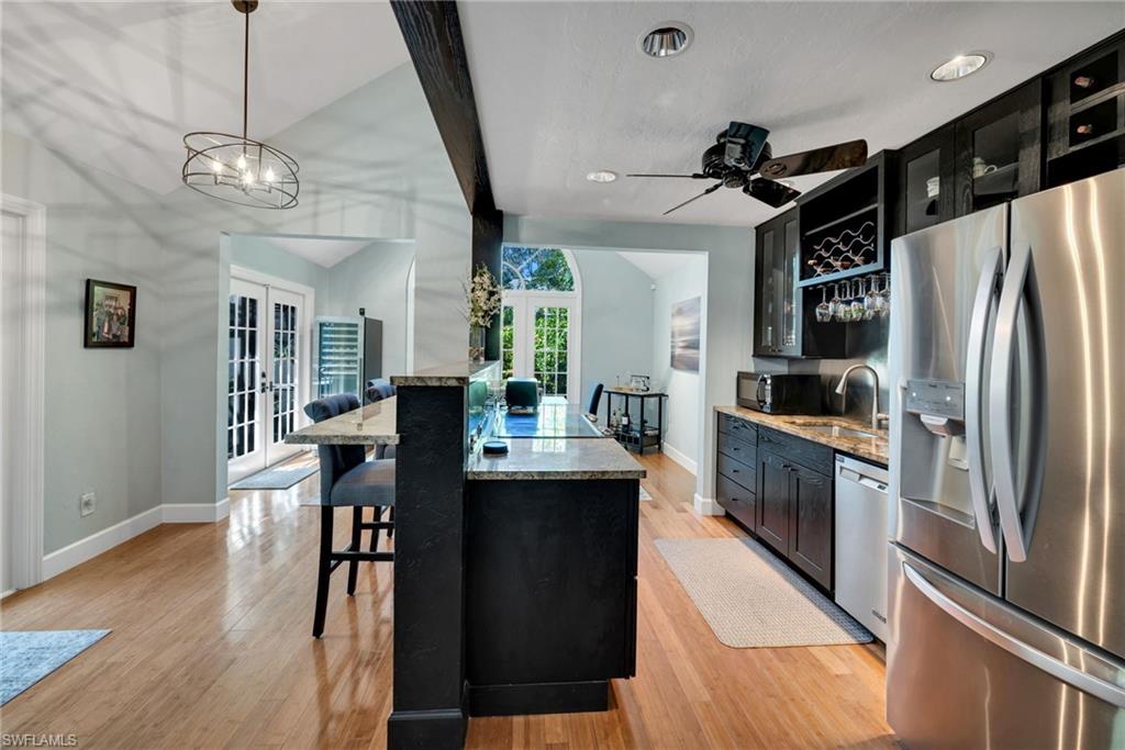 1269 Solana Road, Unit E3 Naples, FL 34103 - Photo 5 of 23 a kitchen with stainless steel appliances a table chairs refrigerator and cabinets