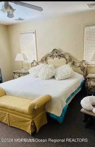 a bedroom with a bed a dresser and painting