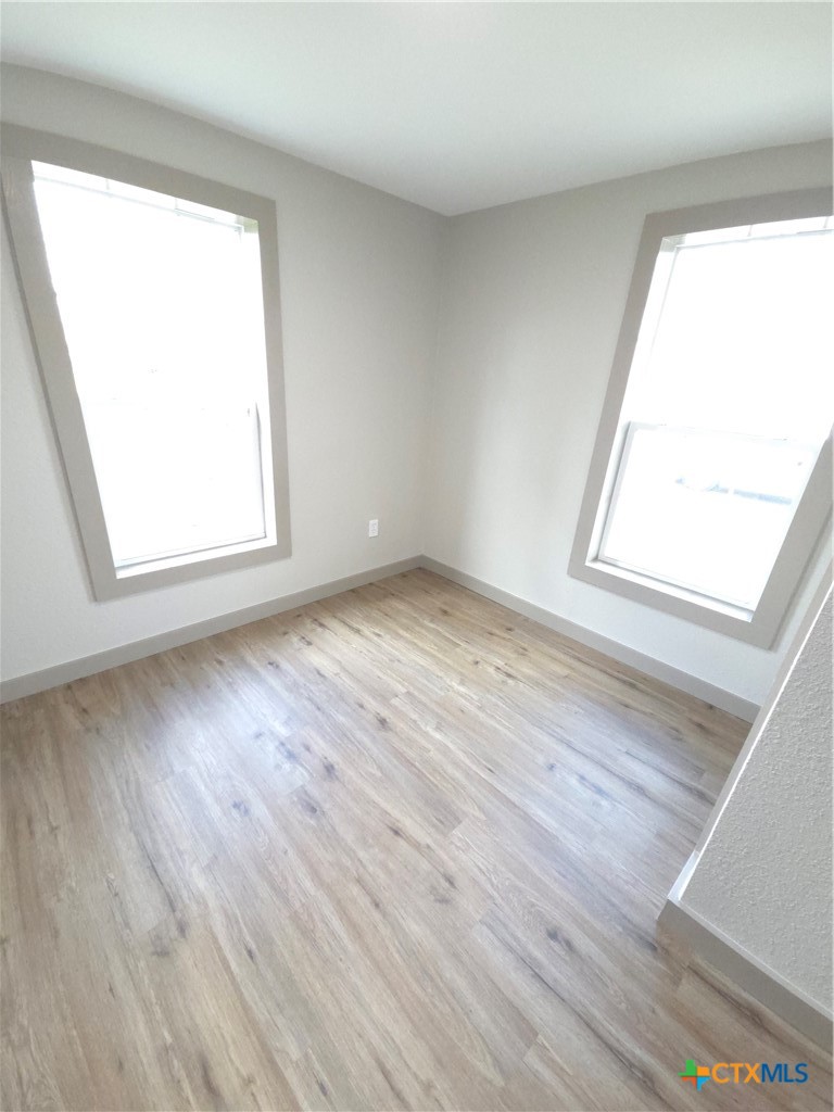 2605 Plainview Street Victoria, TX 77901 - Photo 2 of 16 an empty room with wooden floor and windows