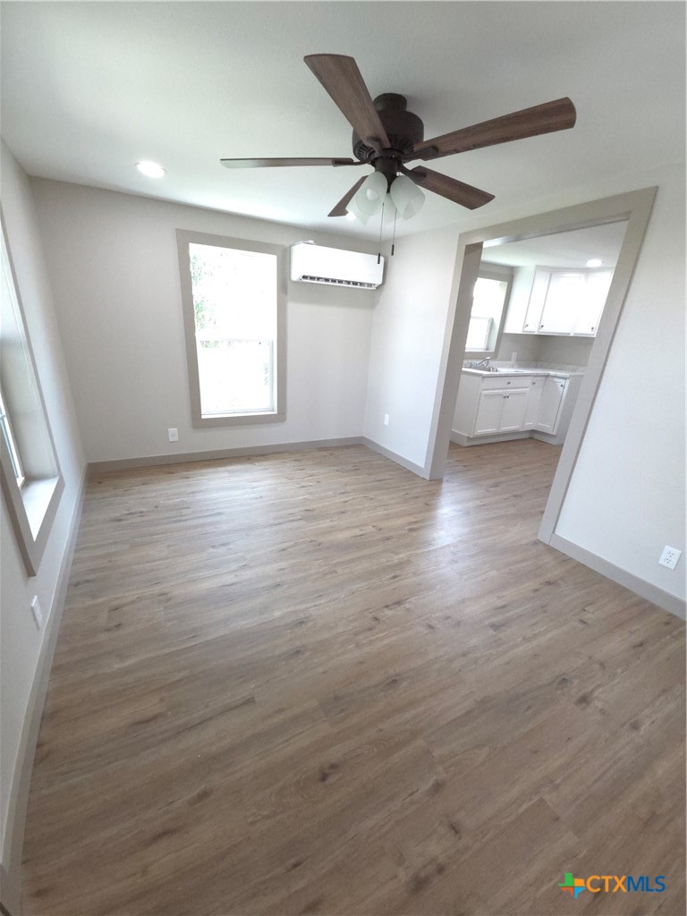 2605 Plainview Street Victoria, TX 77901 - Photo 4 of 16 an empty room with wooden floor fan and windows