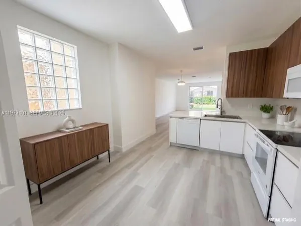 a kitchen with granite countertop a sink cabinets and window