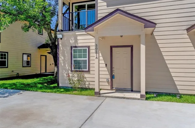 a view of a house with a small yard and a garage