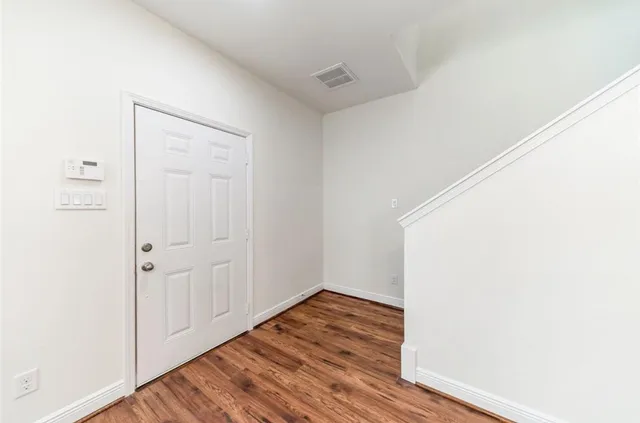 a view of an empty room with wooden floor