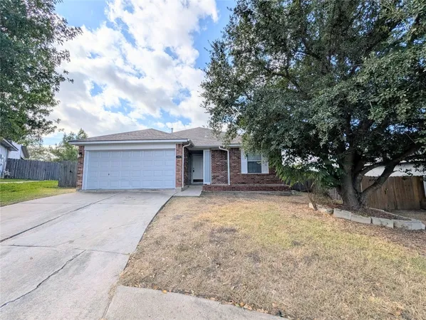 a view of a house with a yard and large tree