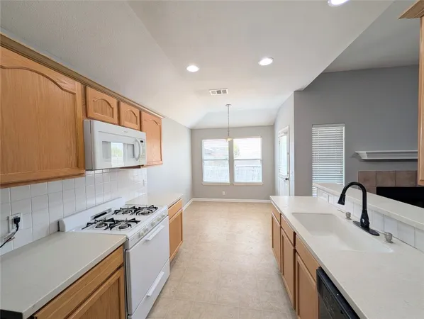 a kitchen with stainless steel appliances a sink stove and cabinets