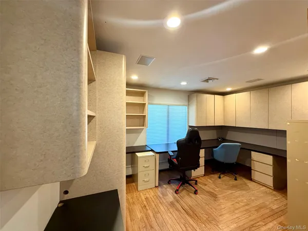 a view of a kitchen with kitchen island a counter top space stainless steel appliances and cabinets