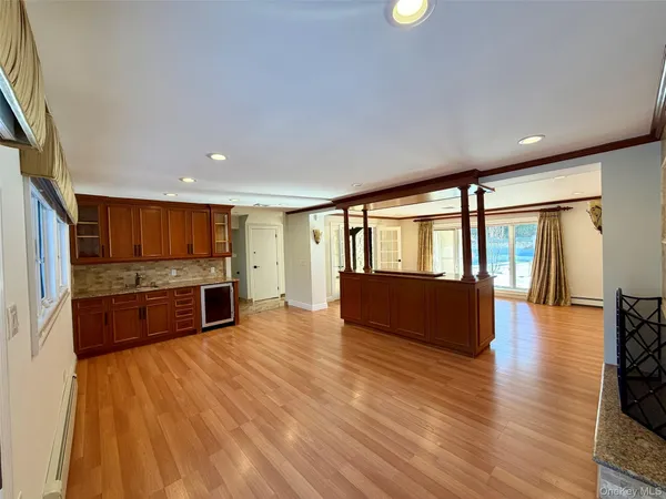 a living room with stainless steel appliances furniture large window and wooden floor