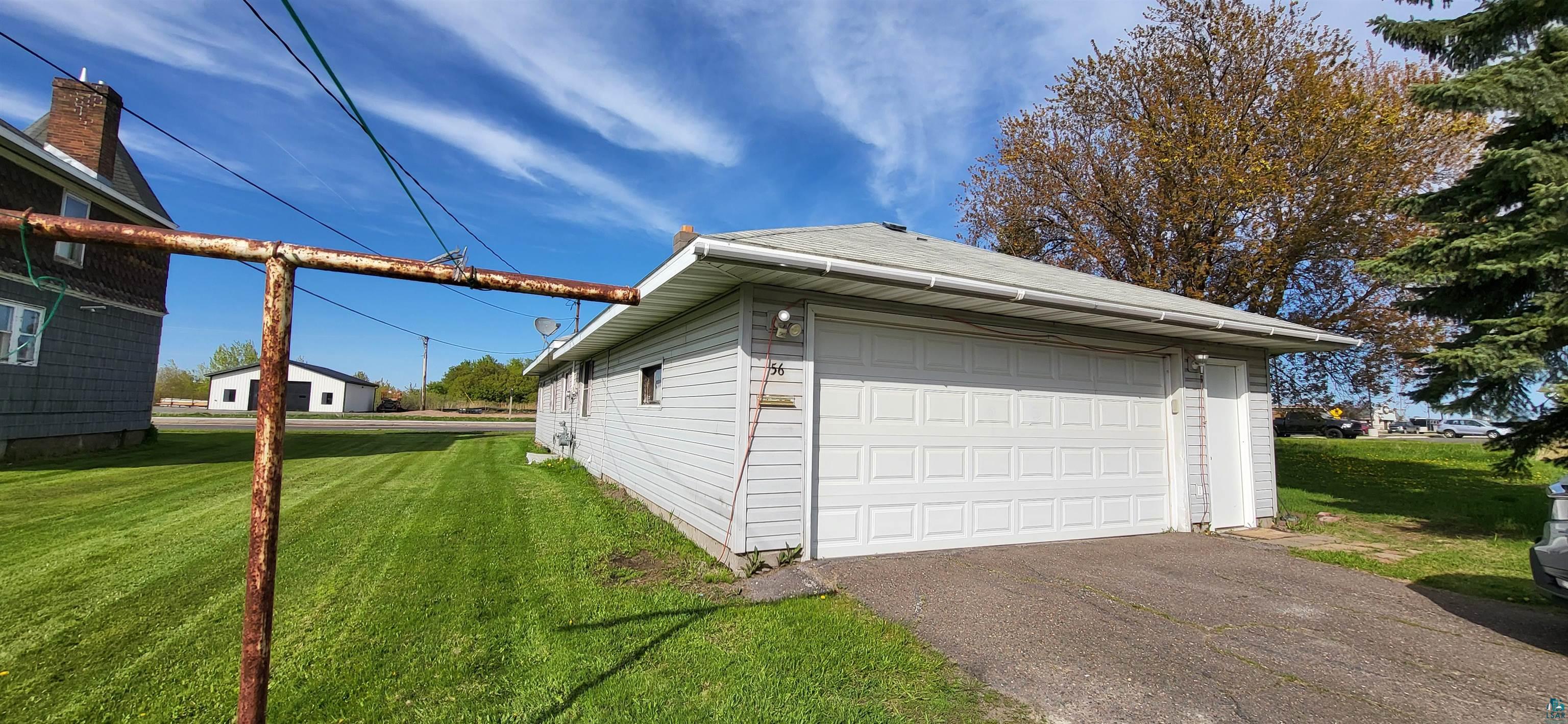 56 East 2nd Street Superior, WI 54880 - Photo 3 of 18 Attached garage with a panel-style door, paved driveway, and side entrance door