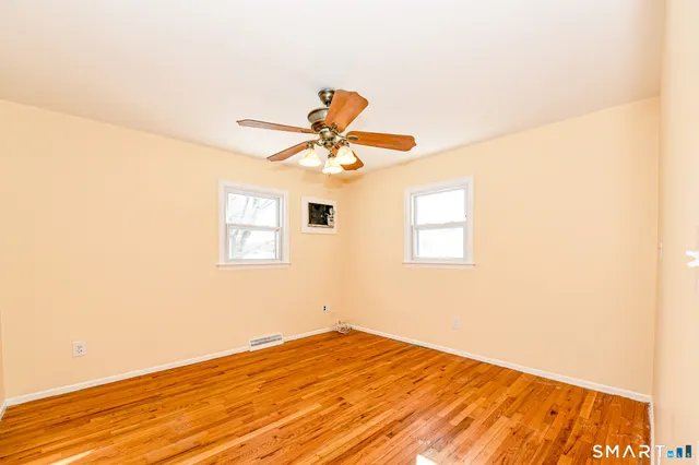 a view of empty room with wooden floor