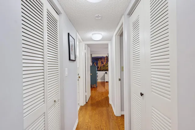 a view of a hallway with wooden floor and staircase