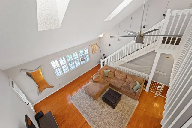 a picture of a living room with furniture and a floor to ceiling window