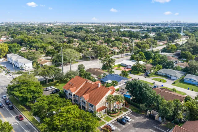 an aerial view of residential houses with outdoor space and trees