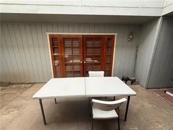 a view of a patio with a table and chairs under an umbrella