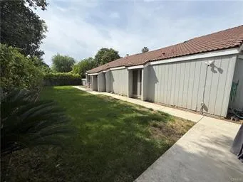 a backyard of a house with plants and large trees