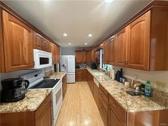 a kitchen with kitchen island granite countertop a sink stove and refrigerator