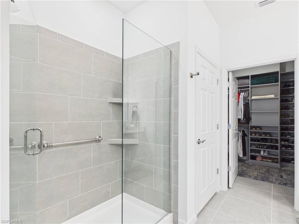 5683 Mayflower Way, Unit 908 Ave Maria, FL 34142 - Photo 26 of 37 Full bathroom featuring a shower stall, a spacious closet, and light tile patterned floors