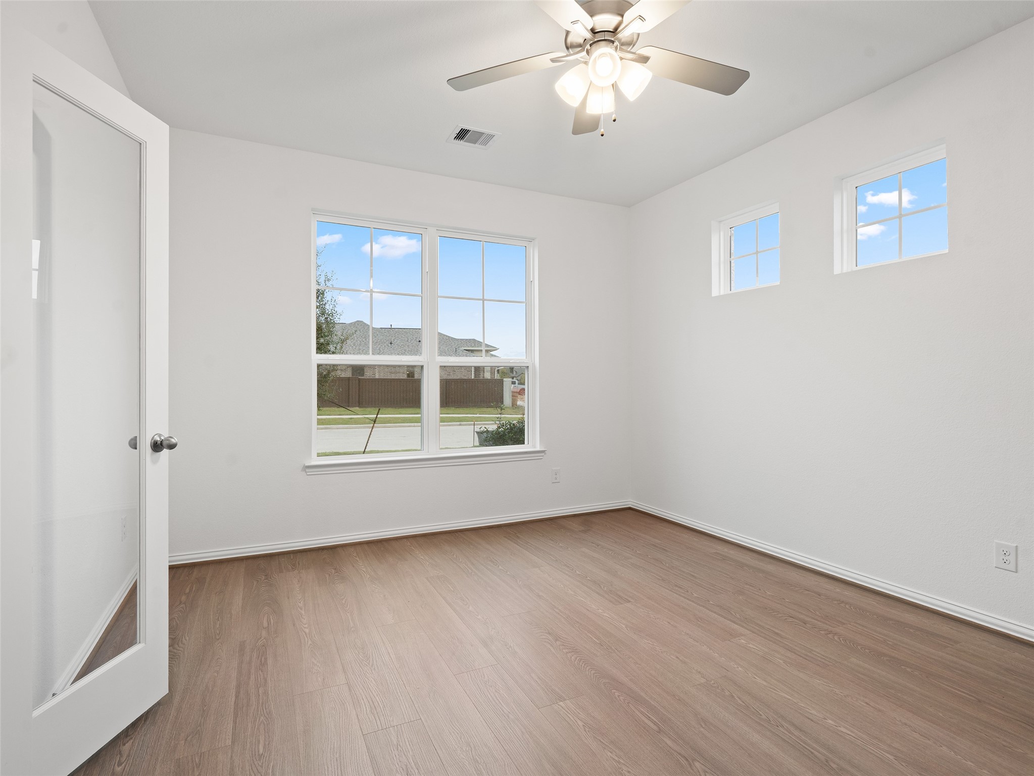 410 Strm Bnd Way Rosenberg, TX 77471 - Photo 7 of 39 wooden floor in an empty room with a window