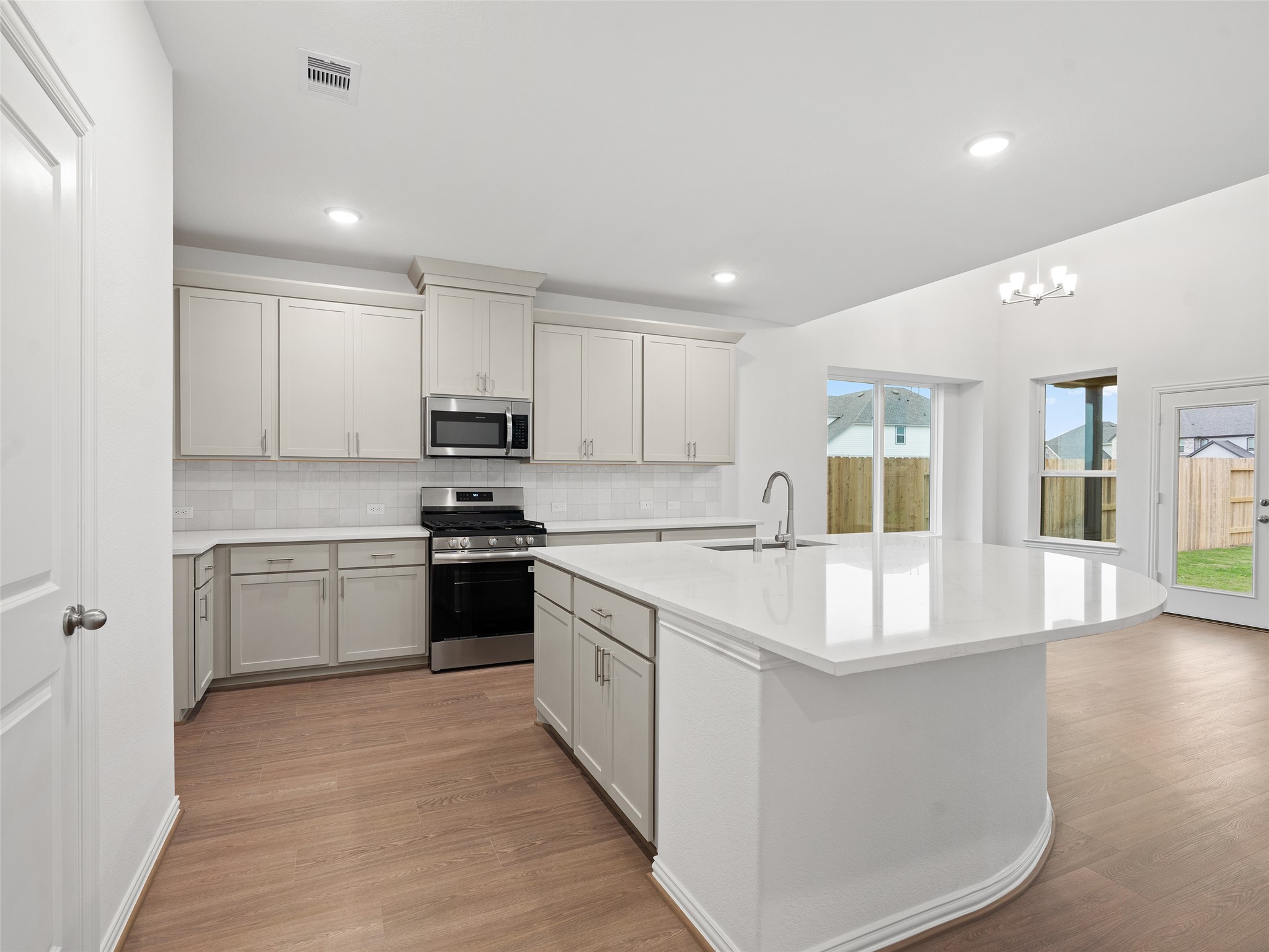 410 Strm Bnd Way Rosenberg, TX 77471 - Photo 9 of 39 a large kitchen with granite countertop a stove top oven a sink a counter space and cabinets