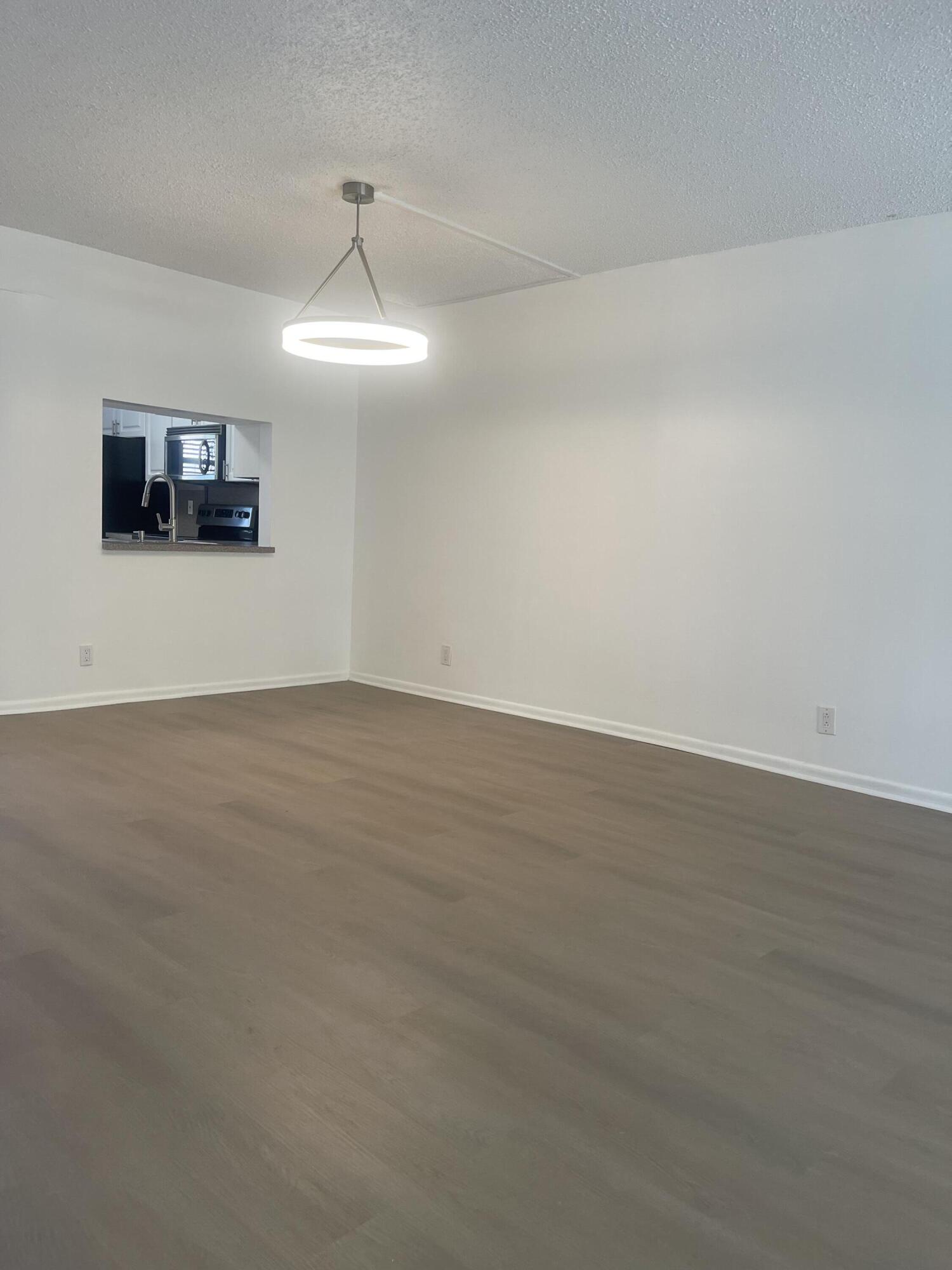 3955 North Nob Hill Road, Unit 202 Sunrise, FL 33351 - Photo 9 of 14 an empty room with wooden floor and ceiling fan