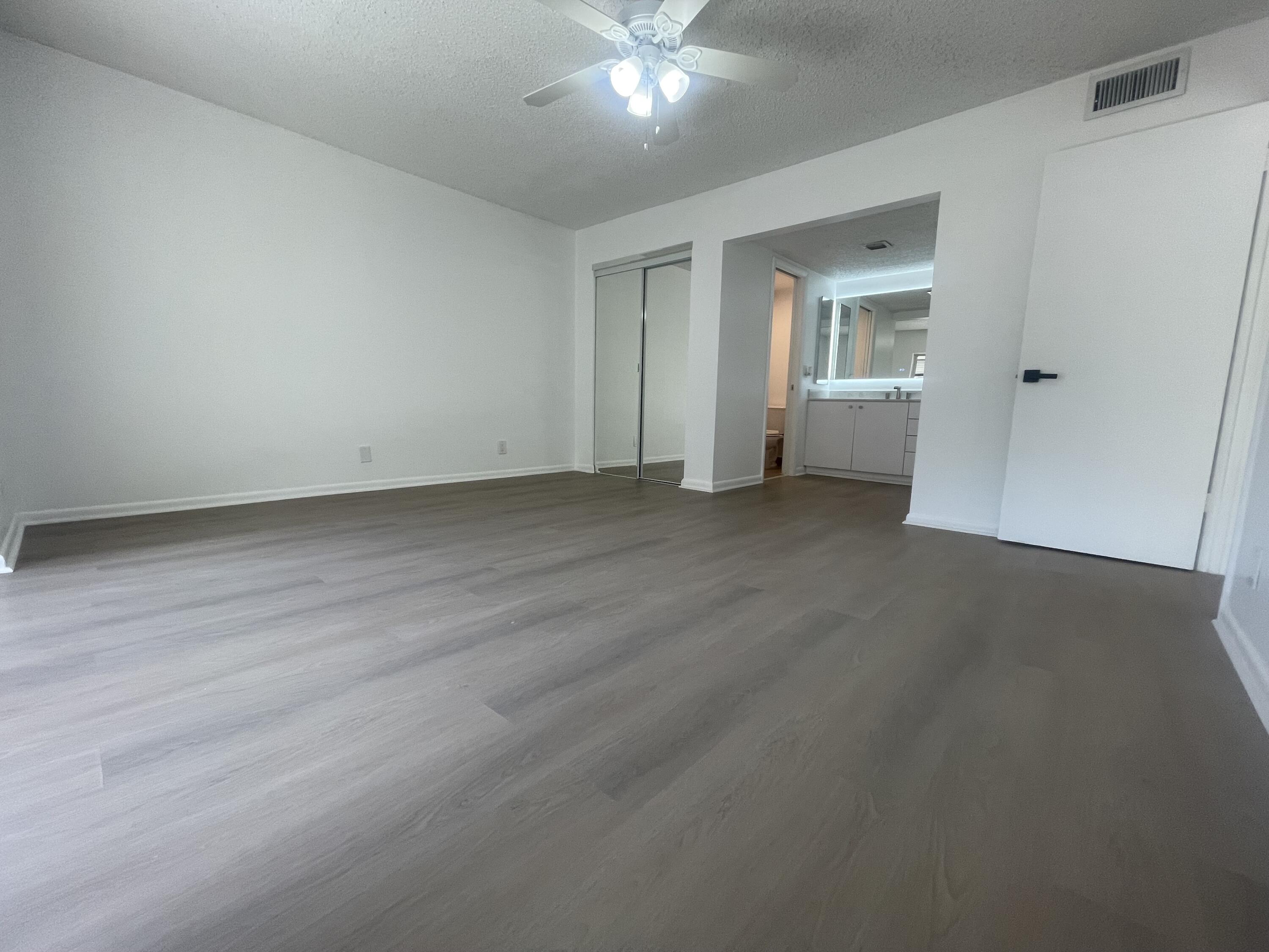 3955 North Nob Hill Road, Unit 202 Sunrise, FL 33351 - Photo 10 of 14 a view of a room with wooden floor and a ceiling fan