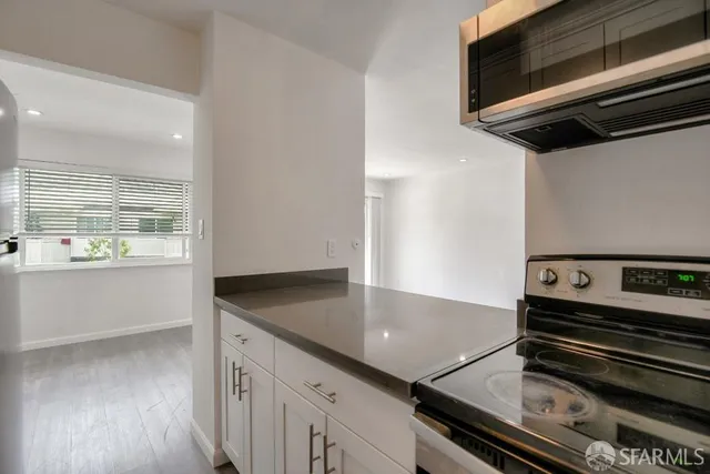 a kitchen with a stove and a wooden floor