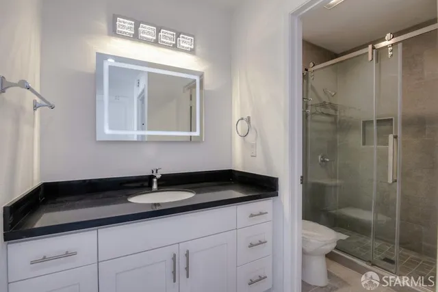 a bathroom with a sink a toilet and shower
