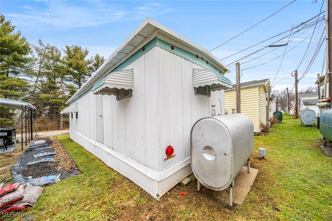 9735 Chillicothe Road, Unit 30 Kirtland, OH 44094 - Photo 6 of 10 View of home's exterior with heating fuel and a yard