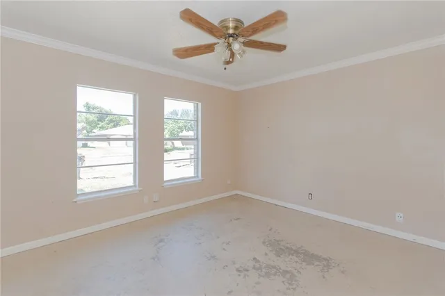 an empty room with a window and a fan