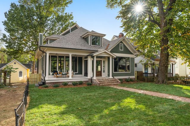 a front view of a house with porch and garden