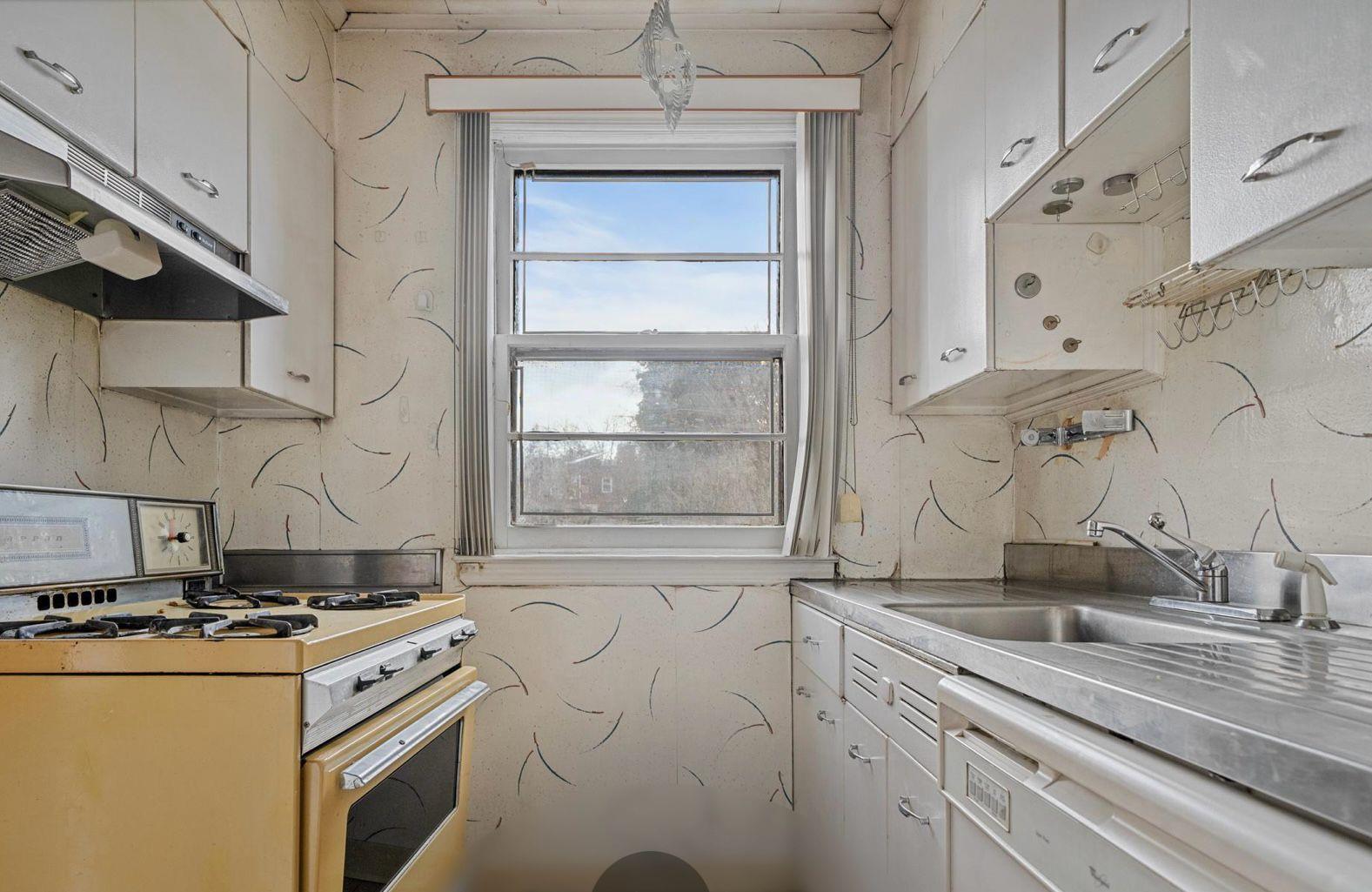 138-12 76th Avenue Queens, NY 11367 - Photo 5 of 12 Kitchen featuring white gas range oven, dishwashing machine, a sink, under cabinet range hood, and white cabinets