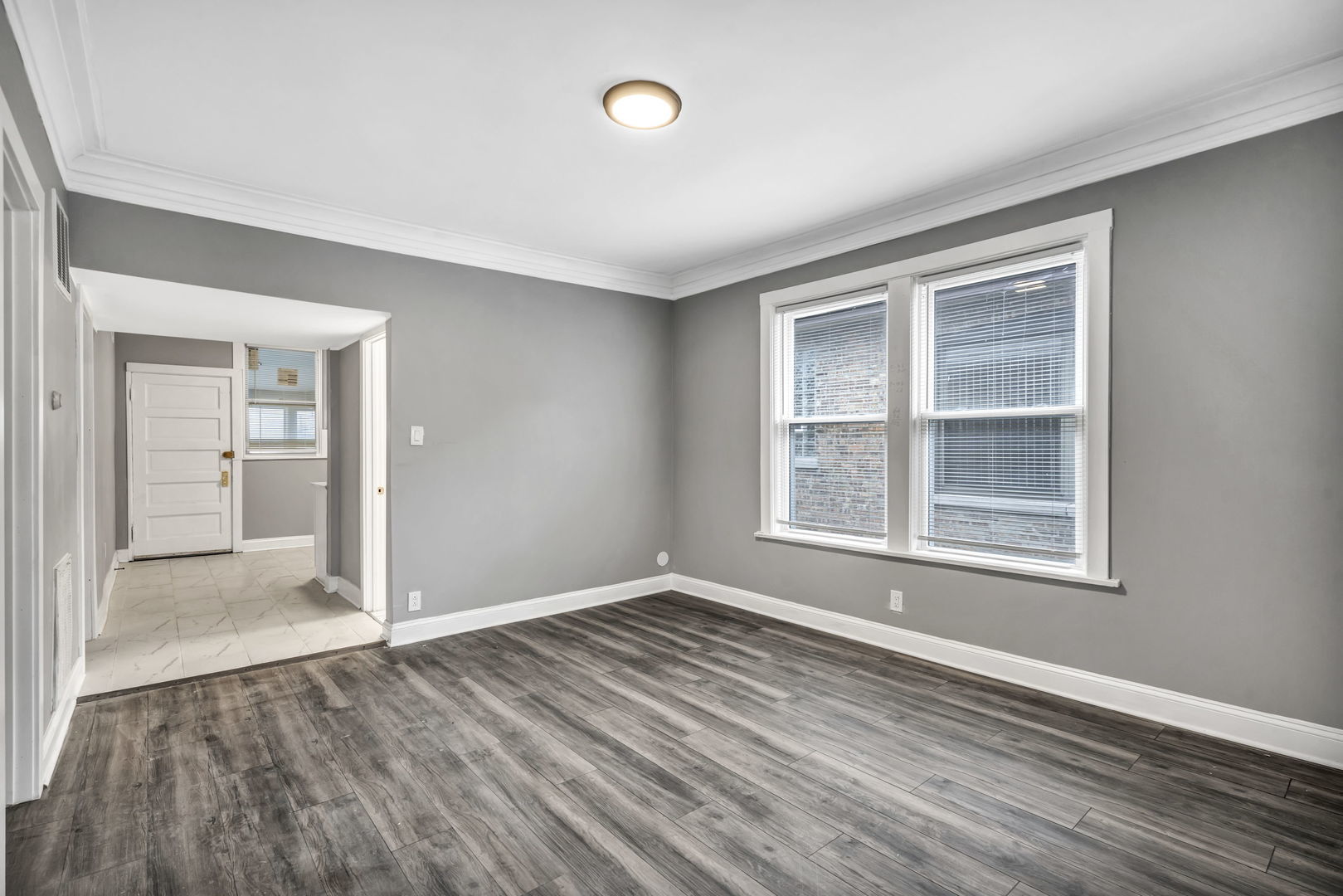 7924 South May Street, Unit 2 Chicago, IL 60620 - Photo 4 of 10 an empty room with wooden floor and windows