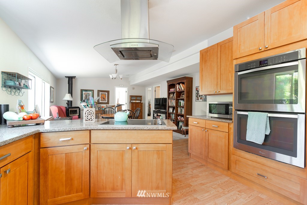 907 240th Place Southwest Bothell, WA 98021 - Photo 2 of 24 a kitchen with stainless steel appliances granite countertop a stove a sink dishwasher and white cabinets with wooden floor
