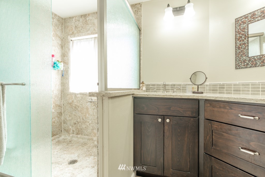 907 240th Place Southwest Bothell, WA 98021 - Photo 15 of 24 a bathroom with a granite countertop sink a mirror and a shower