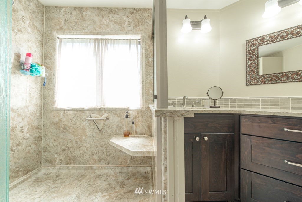 907 240th Place Southwest Bothell, WA 98021 - Photo 17 of 24 a bathroom with a granite countertop sink a mirror and a shower