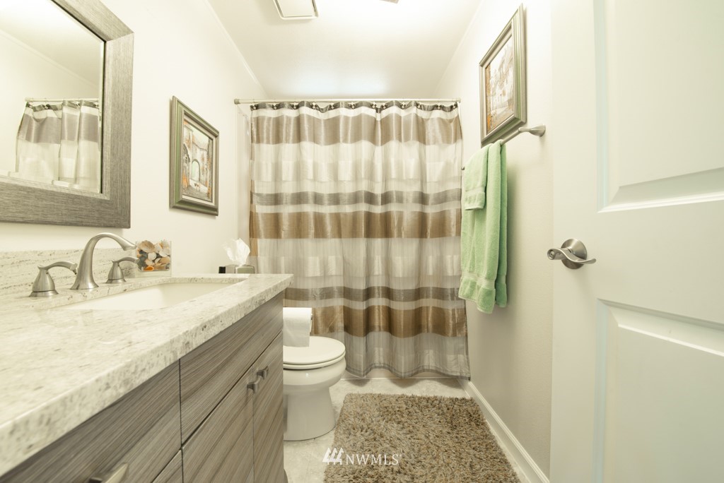 907 240th Place Southwest Bothell, WA 98021 - Photo 19 of 24 a bathroom with a granite countertop sink a toilet and shower