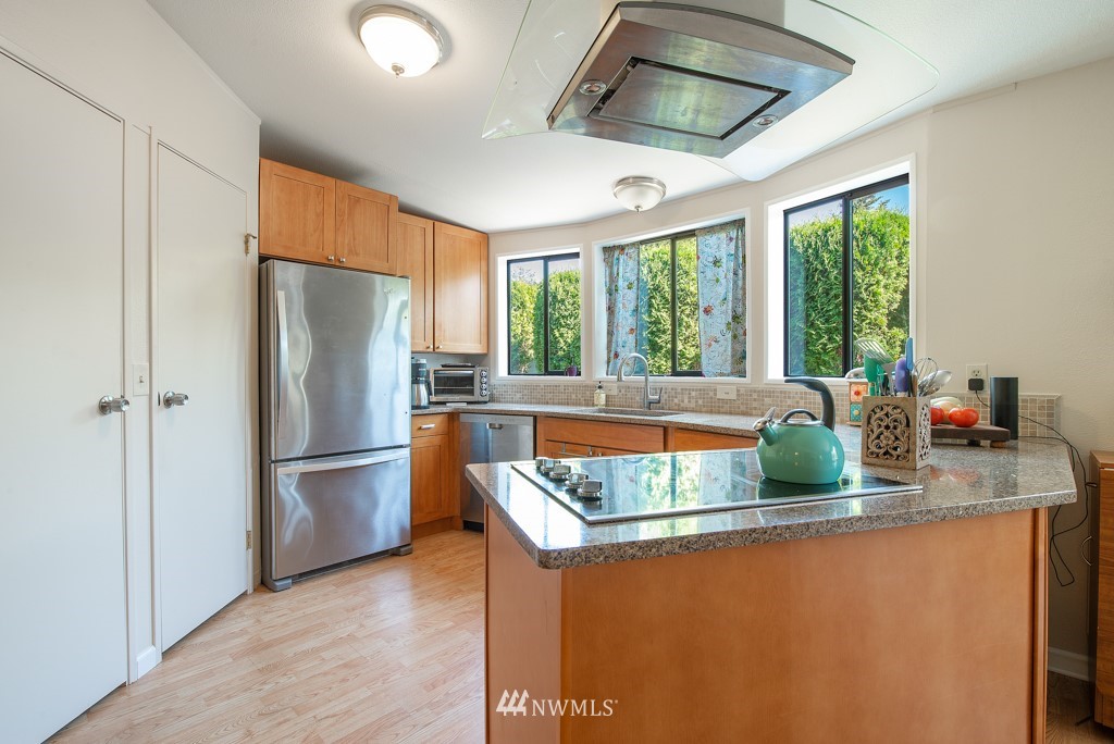 907 240th Place Southwest Bothell, WA 98021 - Photo 4 of 24 a kitchen with stainless steel appliances granite countertop a refrigerator a sink a stove and a refrigerator
