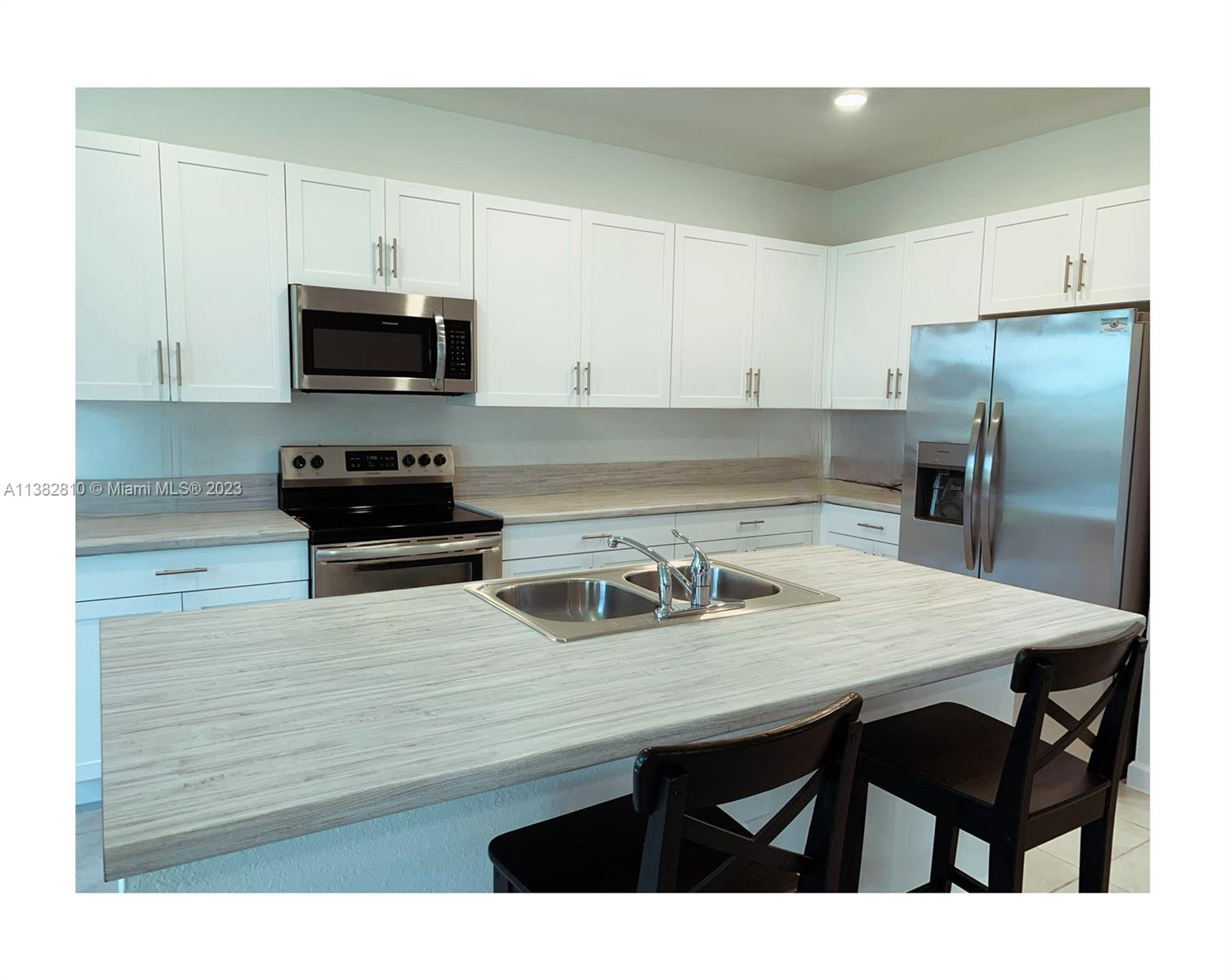 11909 Southwest 244th Street, Unit 11909 Homestead, FL 33032 - Photo 11 of 45 a kitchen with stainless steel appliances a table chairs microwave and sink