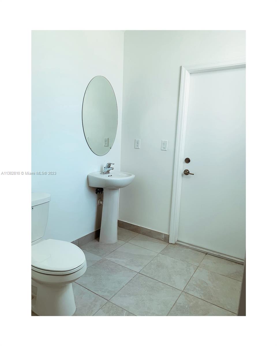 11909 Southwest 244th Street, Unit 11909 Homestead, FL 33032 - Photo 13 of 45 a bathroom with a toilet a sink and a mirror
