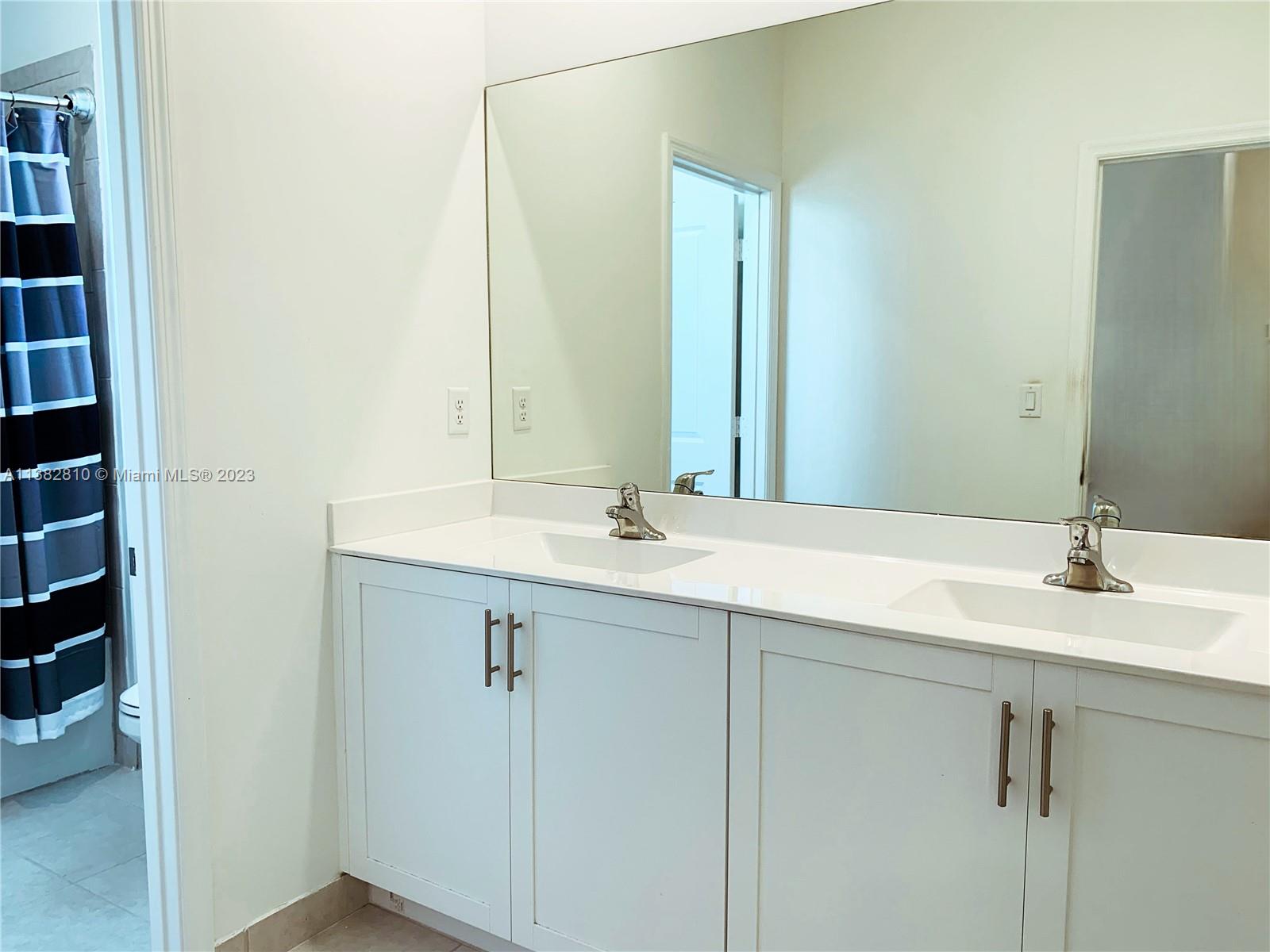 11909 Southwest 244th Street, Unit 11909 Homestead, FL 33032 - Photo 17 of 45 a bathroom with a sink and a mirror
