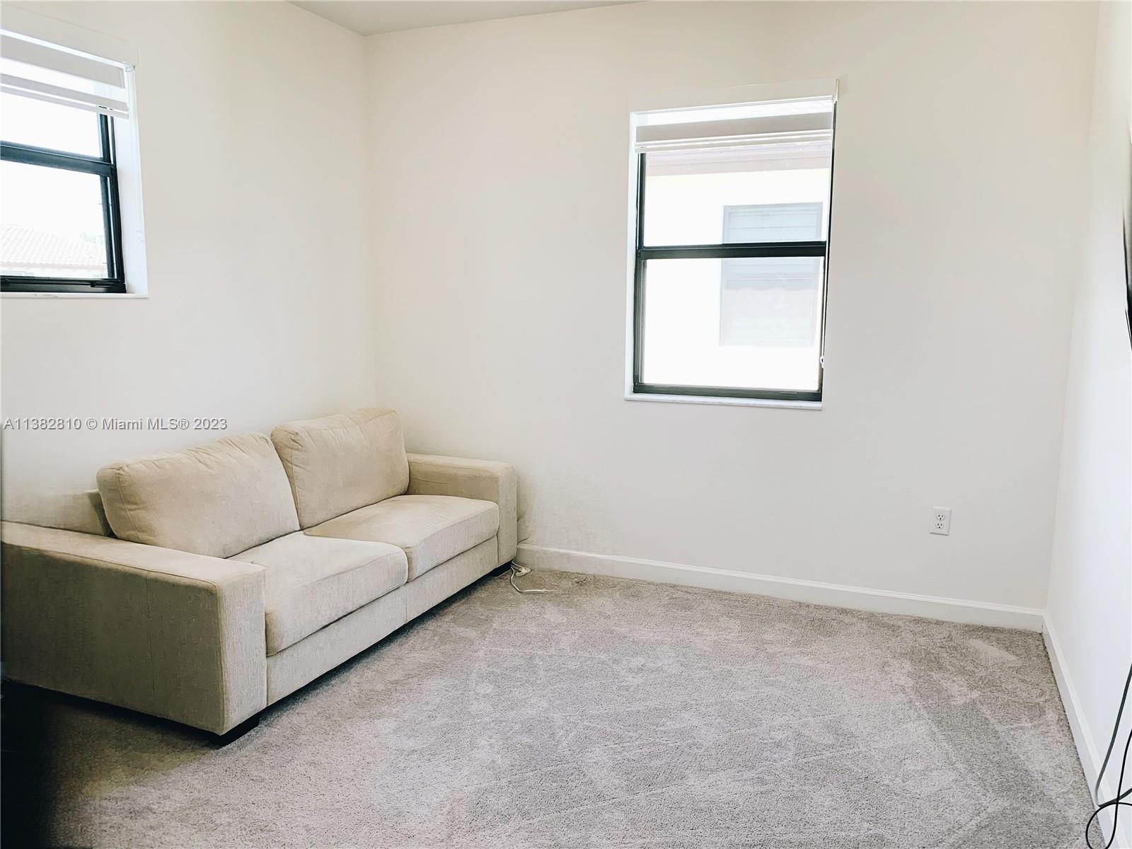 11909 Southwest 244th Street, Unit 11909 Homestead, FL 33032 - Photo 20 of 45 a living room with furniture and a window