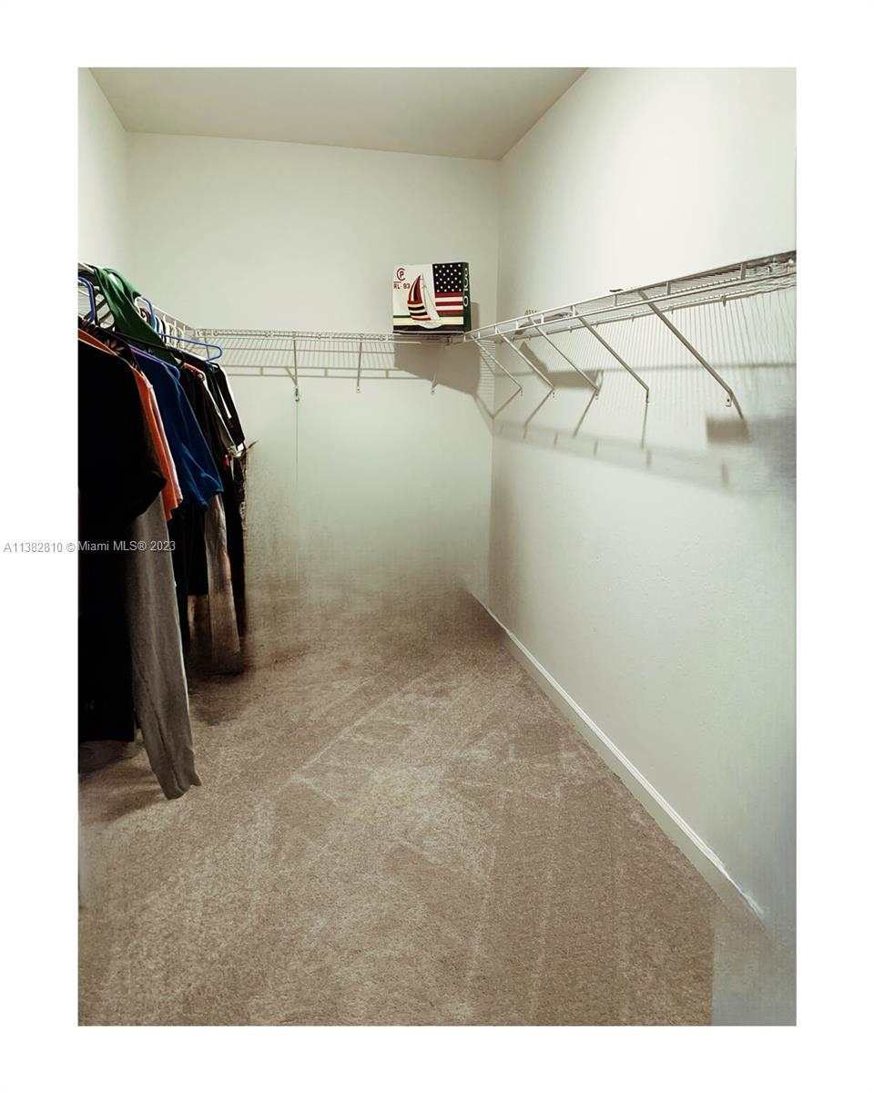 11909 Southwest 244th Street, Unit 11909 Homestead, FL 33032 - Photo 33 of 45 a view of walk in closet with clothes and shoes