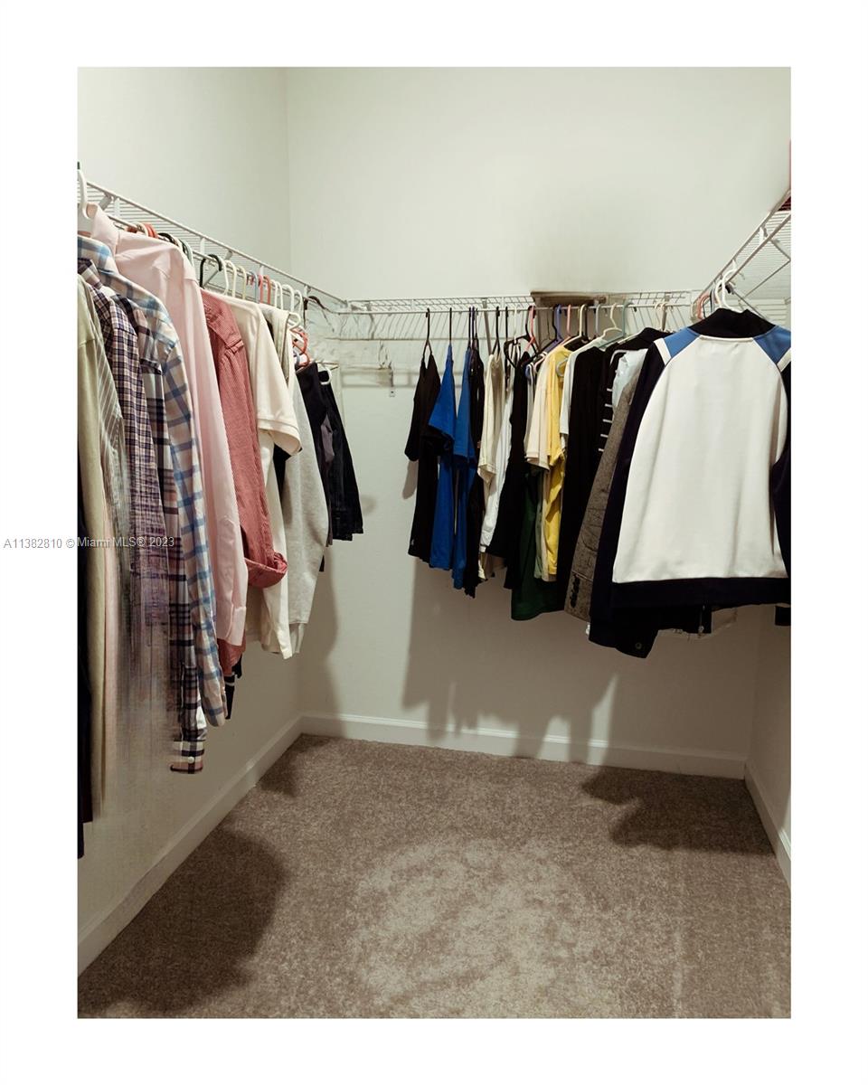 11909 Southwest 244th Street, Unit 11909 Homestead, FL 33032 - Photo 34 of 45 a view of walk in closet with clothes and shoes